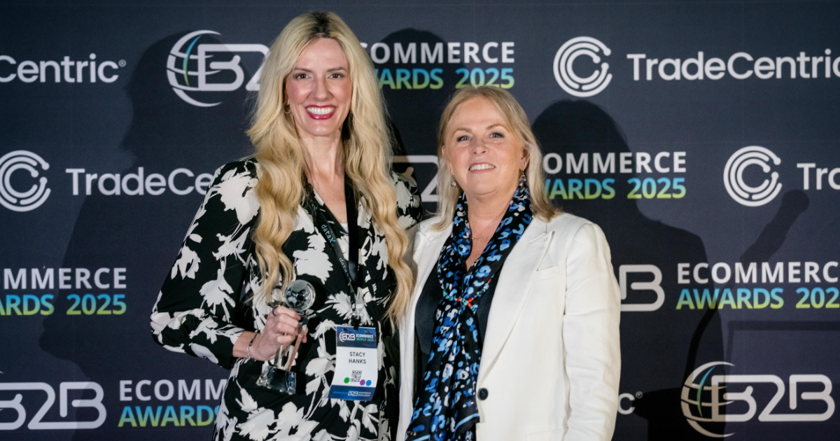 two women smiling holding an award
